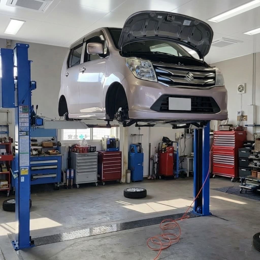 リフトで持ち上げられた軽自動車と整備工場内の様子